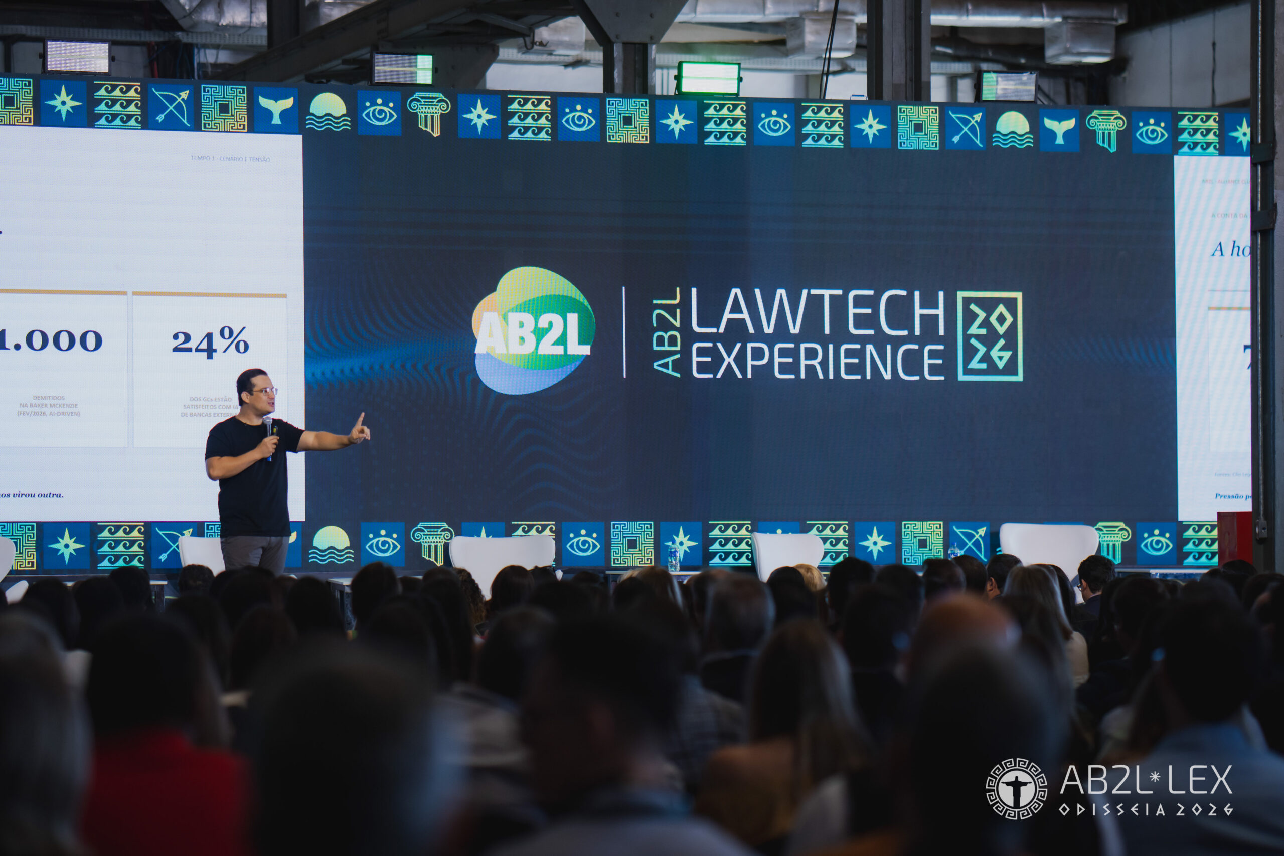 Auditório com painel digital conectando símbolos do direito e tecnologia jurídica